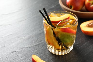 Bardakta buzlu şeftali çayı ve gri masada taze meyveler, yakın plan. Metin için boşluk