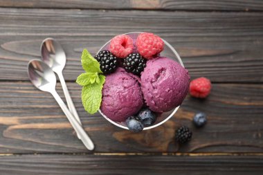 Taze böğürtlenli lezzetli şerbet ve ahşap masada nane şekeri.