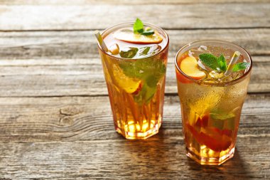 Buzlu şeftali çayını ahşap masadaki bardaklarda tazeliyorum. Yakın plan. Metin için boşluk