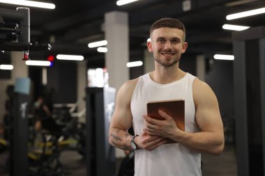 Spor merkezinde tableti olan kişisel antrenör.