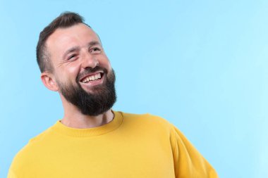 Açık mavi arka planda gülen yakışıklı bir adam. Metin için boşluk