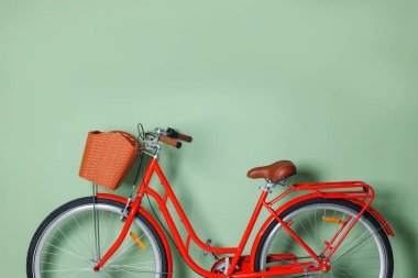 Açık yeşil duvarın yanında sepeti olan kırmızı bisiklet. Metin için boşluk
