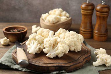 Taze taze karnabahar çiçekleri, baharatlar ve bıçak ahşap masada, yakın plan.