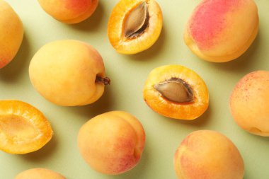 Soluk yeşil arka planda taze taze kayısılar, düz uzanmış.