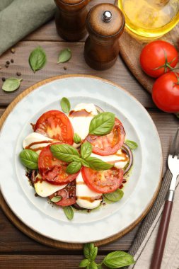 Caprese salatası ahşap masada balzamik sirkeyle servis edilir.