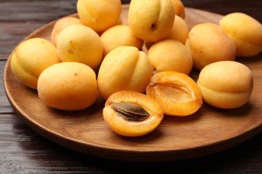 Ahşap masada bir sürü taze kayısı, yakın plan.