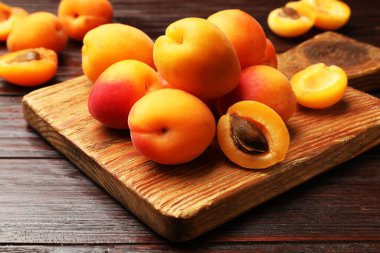 Ahşap masada bir sürü taze kayısı, yakın plan.