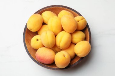 Taze kayısılar beyaz masada kasede, üst tarafta.