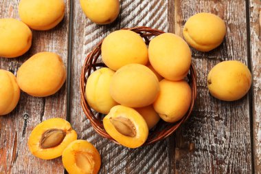 Taze kayısılar hasır sepetin içinde, ahşap masanın üstünde, düz yatıyordu.