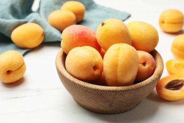 Taze kayısılar kasede beyaz mermer masada, yakın plan.