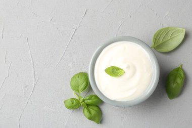 Açık gri masada fesleğende fesleğen olan lezzetli yoğurt. Metin için boşluk