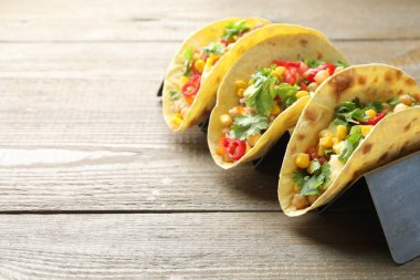 Tahta masada servis edilen nohut, mısır ve kinoalı lezzetli vejetaryen tacolar, yakın plan. Metin için boşluk