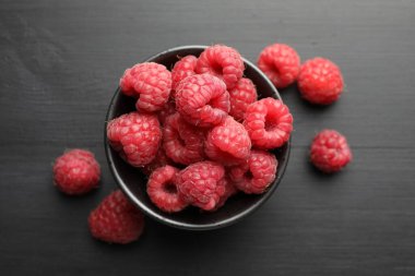 Lezzetli olgun ahududular siyah masada, düz yatıyordu.