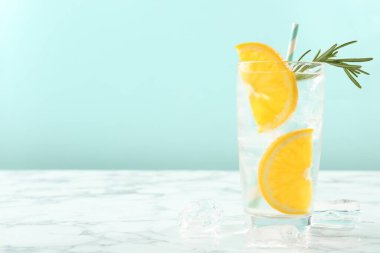 Portakal dilimli soda ve beyaz mermer masada biberiye, yakın plan. Metin için boşluk