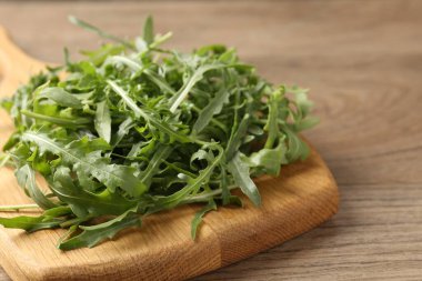 Taze yeşil roka yaprakları ahşap masada, yakın plan.