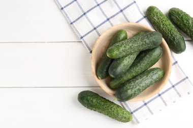 Taze salatalıklar beyaz ahşap masada, düz yerde. Metin için boşluk