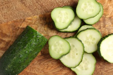 Tahta masada taze salatalık dilimleri, düz uzanmış.