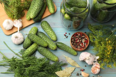 Turşu yapıyorum. Taze salatalıklar ve diğer malzemeler açık mavi ahşap masa, düz uzanmış