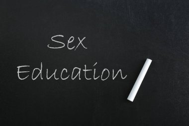 Seks Eğitimi yazıtları ve kara karatahtanın üzerindeki tebeşir parçası