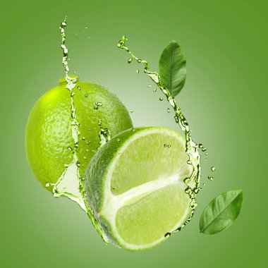 Taze limonlar, yapraklar ve içecekler yeşil arka planda havada sıçrıyor.