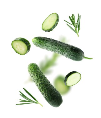 Beyaz arka plana düşen taze salatalıklar ve biberiye.