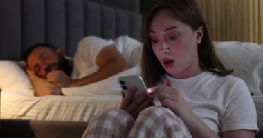 İhanet. Kıskanç kadın, sadakatsiz kocasının kanıtlarını uyurken akıllı telefondan buluyor ve onu yatak odasında uyandırıyor.