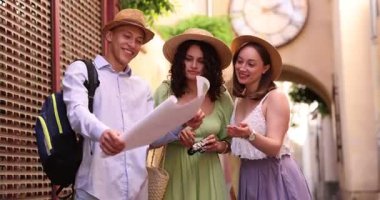 Şehir caddesinde haritalı turistler yürüyor