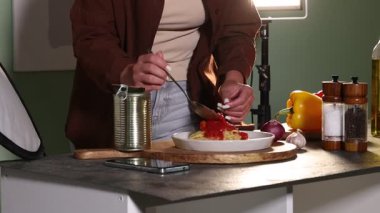 Stüdyodaki masada fotoşoplar için lezzetli makarnayla kompozisyon hazırlayan kadın, kamera hareket ediyor. Profesyonel yemek fotoğrafçılığı.