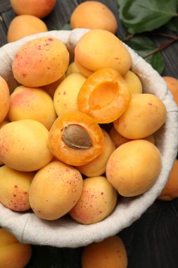 Taze kayısılar sepetin içinde, ahşap masanın üzerinde, düz yatıyordu.