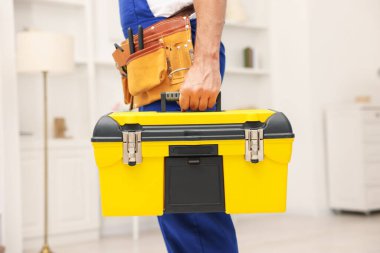 Kapalı mekanda alet çantası olan profesyonel bir tamirci.