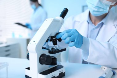 Tıbbi analiz. Laboratuvarda mikroskopla çalışan bilim adamı, seçici odaklanma