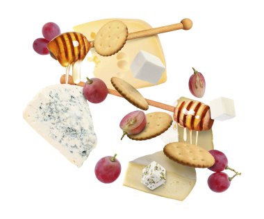 Peynir ürünleri beyaz arka planda havada. Farklı peynir, üzüm, kraker ve bal çeşitleri.