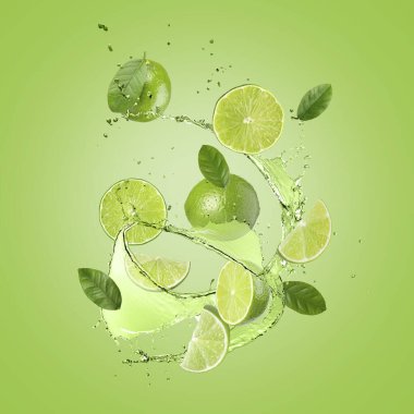 Taze limonlar, yapraklar ve içecekler yeşil arka planda havada sıçrıyor.