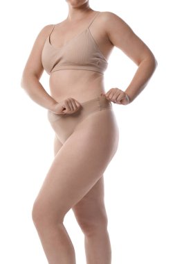 Yağ aldırma. Beyaz arka planda iç çamaşırlı kadın, yakın plan.