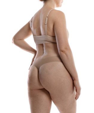 Yağ aldırma. Beyaz arka planda iç çamaşırlı kadın, yakın plan.