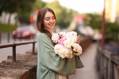 Şehir caddesinde bir buket güzel şakayığı olan çekici bir kadın. Metin için boşluk