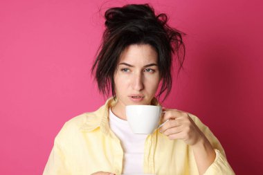 Kırmızı arka planda akşamdan kalma içki içen bir kadın.