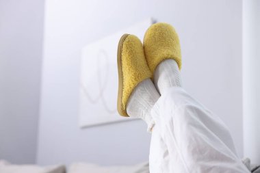 Evdeki yumuşak sarı terlikli kadın, yakın plan. Metin için boşluk