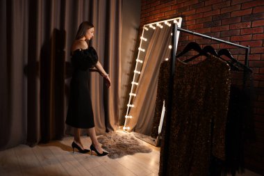 İçeride aynanın yanında bilezik takan güzel bir kadın.