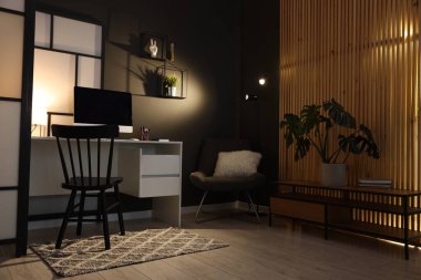 Ofiste masası, bilgisayarı ve koltuğu olan şık bir iş yeri. İç tasarım