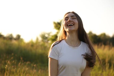 Özgürlüğü hissetmek. Mutlu genç kadın doğada vakit geçiriyor, mesaj için yer var.