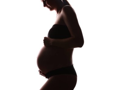 Beyaz arka planda hamile kadın silueti, yakın plan.