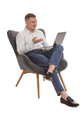 Çevrimiçi oturum sırasında gülümseyen psikolog dizüstü bilgisayarla beyaz arka planda oturuyor.