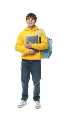 Beyaz arka planda dizüstü bilgisayarı ve sırt çantası olan genç bir çocuk.