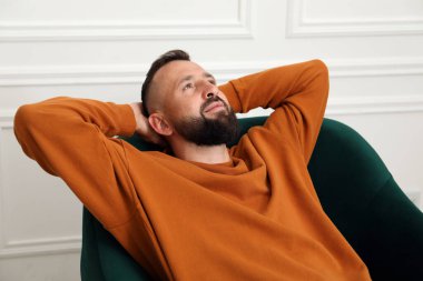 Uyum. Evdeki rahat koltukta dinlenen adam.