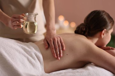 Kaplıcada kadın yağ ile masaj yaptırıyor, yakın plan.