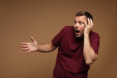 Kahverengi arka planda panik atak geçiren bir adam.