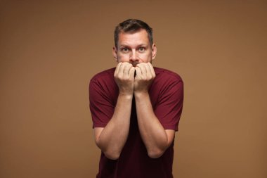 Kahverengi arka planda panik atak geçiren bir adam.