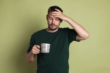 Bir bardak içkisi olan adam zeytin arka planında akşamdan kalma.