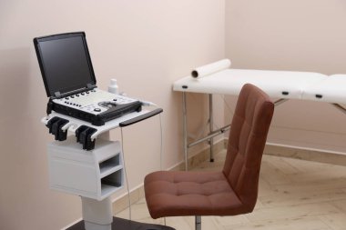 Klinikte modern ultrason makinesi, sandalye ve muayene yatağı
